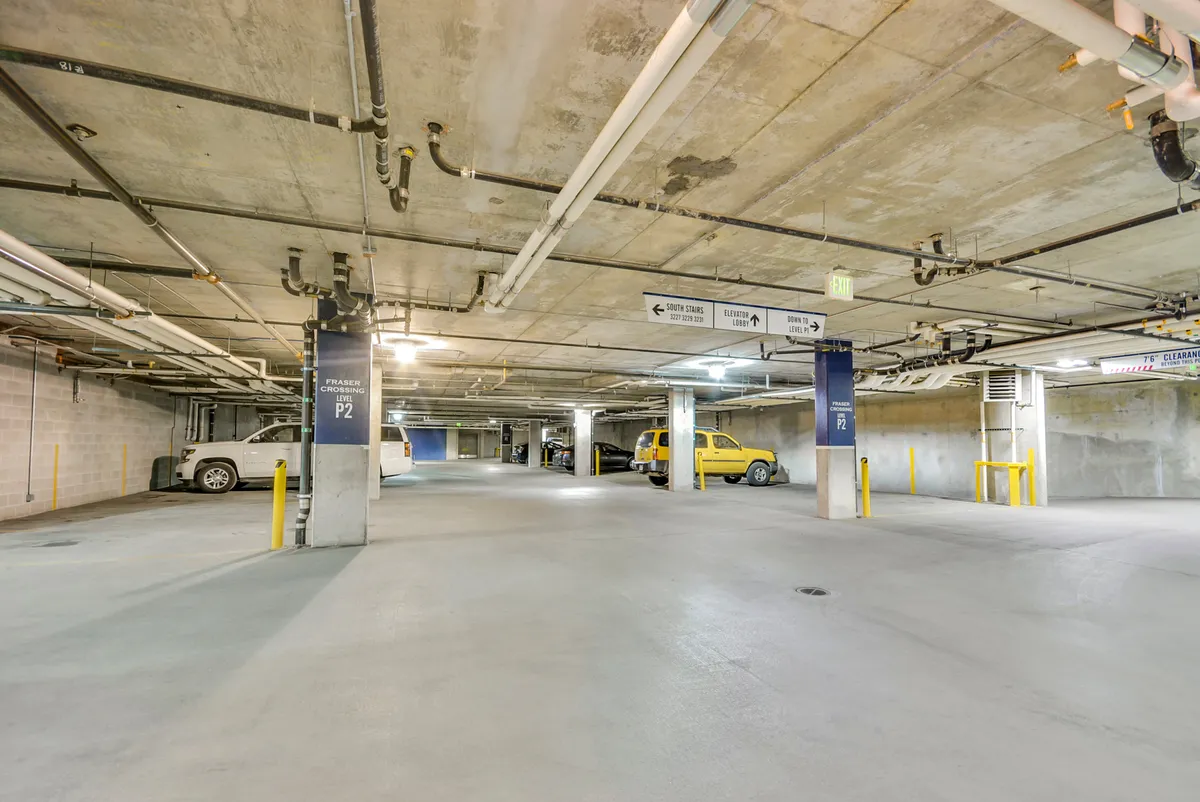This interior image shows the heated underground parking garage, featuring a yellow car, clear signage, and organized parking spaces. The practical and well-maintained facility underscores the convenience and security offered to guests.